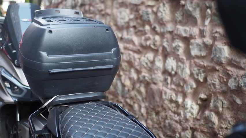 Motorcycle parked at an urban location next to a stone wall