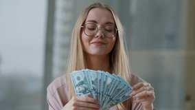 Happy smiling Caucasian business woman holding money throwing one banknote smile positive businesswoman female girl holding cash in office finance success rich successful bet employer with dollars - Powered by Shutterstock - Get 15% off with code: PIKWIZARD15