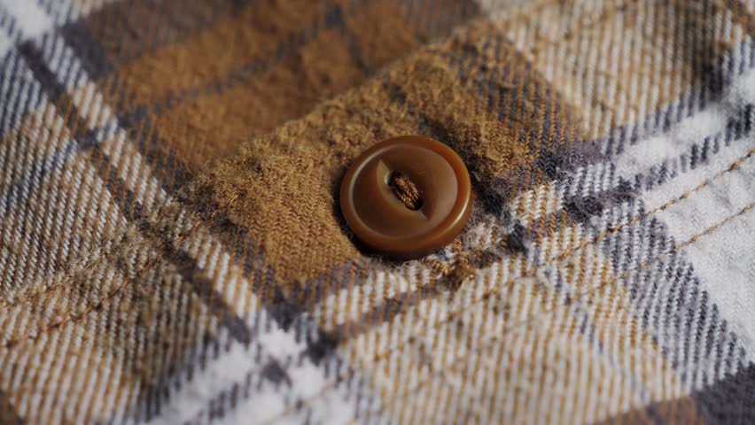 Plaid fabric close-up. Part of shirt with button.Texture and background. High quality 4k footage