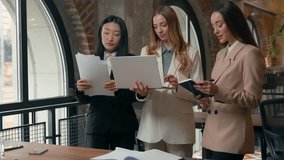 Emotional talking busy business team multiracial women working together corporate brainstorm businesswomen multiethnic females girls with laptop documents in office discuss planning corporate strategy - Powered by Shutterstock - Get 15% off with code: PIKWIZARD15