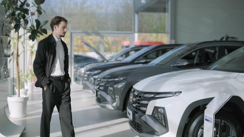 Car buyers exploring vehicles with sales agent assistance at dealership