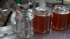 Honey is being poured into a glass jar on a production line, capturing the filling action and the rich amber color of the liquid, highlighting the production process - Powered by Shutterstock - Get 15% off with code: PIKWIZARD15