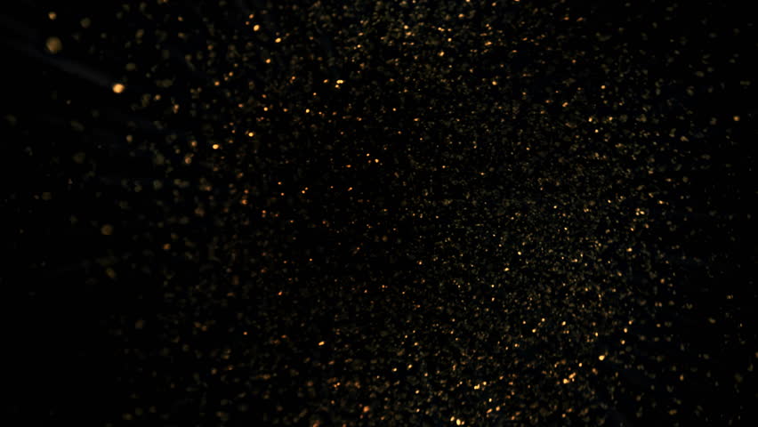 Super Slow Motion Shot of Rotating Golden Glitters Towards Camera Isolated on Black 1000fps.