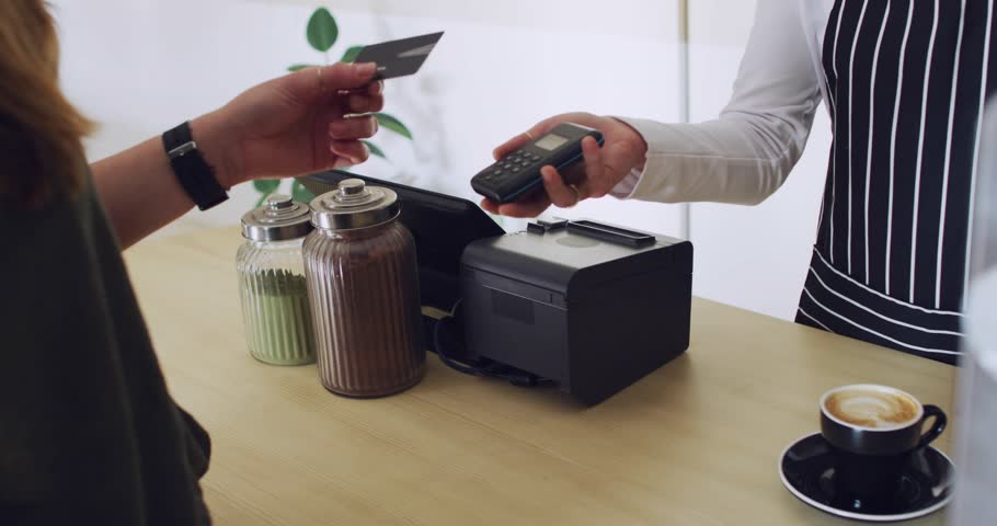 Customer tapping card, paying for coffee as staff holding reader serving cup amid confetti. Payment, transaction, contactless, terminal, cafe, counter, efficiency