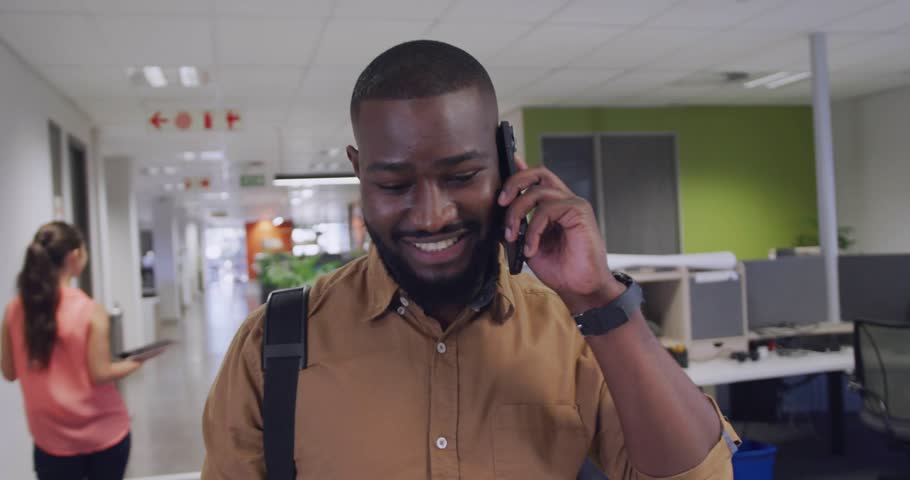 Man walking office, speaking on cell and starting chat bubbles clustering around him for updates. Professional, smartphone, backpack, openplan, motiongraphics, corporate, workplace