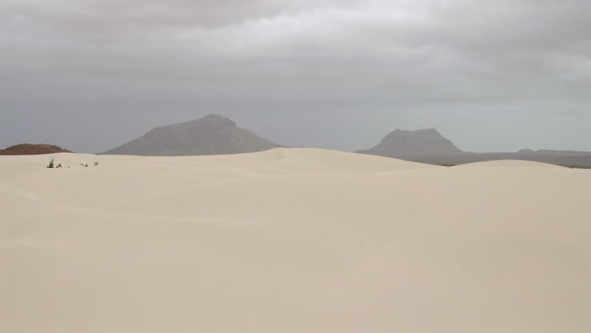Sand dunes in Viana desert close up at overcast day, background volcanic mountains, Boa vista , Cape Verde.