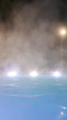 Steamy Night Swimming Pool with Bright Underwater Lights