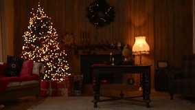Cozy, warm Christmas scene with a decorated tree, glowing lights, fireplace, and rustic wood-paneled wall, creating a nostalgic holiday atmosphere. - Powered by Shutterstock - Get 15% off with code: PIKWIZARD15