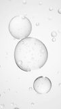 Macro of three drops of transparent liquid merge into one with bubbles inside on white backdrop. Skin care serum droplets uniting into one. Cosmetics moisturizer fluid concept Vertical video - Powered by Shutterstock - Get 15% off with code: PIKWIZARD15