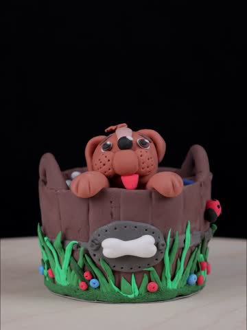 Toy dog in a basket, made of airy plasticine material. 