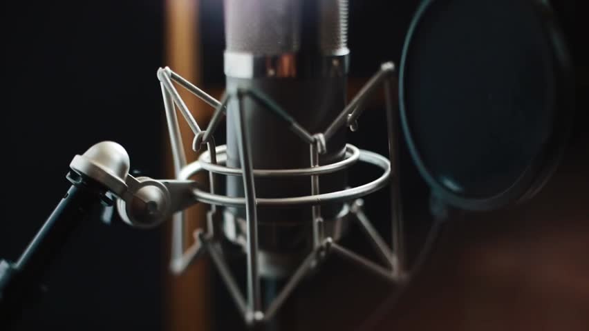 Close-up of a professional microphone in a recording studio, perfect for music, radio, podcasts, entertainment, and audio production visuals.