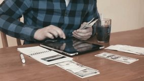 Young man checking and analyzing household bills on a digital tablet at home. Personal finance management, online payments, budgeting and modern technology lifestyle. - Powered by Shutterstock - Get 15% off with code: PIKWIZARD15