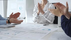 Business people team clapping hands in meeting celebrating success with financial charts, data analysis, and teamwork achievement in modern office - Powered by Shutterstock - Get 15% off with code: PIKWIZARD15
