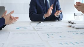 Businesspeople team clapping hands in meeting celebrating success with financial charts, data analysis, sales growth reports, and teamwork achievement in modern office. Business handshake - Powered by Shutterstock - Get 15% off with code: PIKWIZARD15