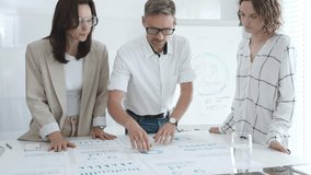 Professional team analyzing financial charts, colleagues reviewing data with focused expressions in modern workplace setting. Business people concept - Powered by Shutterstock - Get 15% off with code: PIKWIZARD15