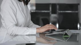 Businesswoman hands using a digital tablet while working at an office glass desk, focused on corporate operations, mobile technology, and data management in a professional workspace - Powered by Shutterstock - Get 15% off with code: PIKWIZARD15