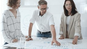 Professional team analyzing financial charts, colleagues reviewing data with focused expressions in modern workplace setting. Business people concept - Powered by Shutterstock - Get 15% off with code: PIKWIZARD15