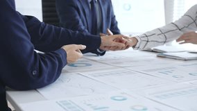 Teamwork and business collaboration with colleagues joining hands over financial charts, symbolizing unity, partnership, success, and strategic corporate planning - Powered by Shutterstock - Get 15% off with code: PIKWIZARD15