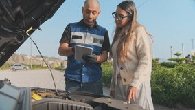 Professional auto mechanic showing diagnostics on a tablet to a female client by a broken car - Powered by Shutterstock - Get 15% off with code: PIKWIZARD15