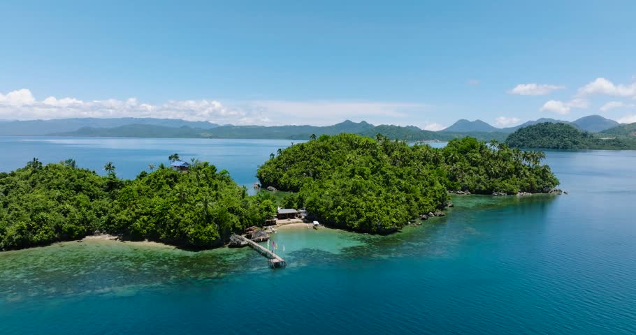 Aerial view of turquoise sea water and coral reefs in tropical island with resorts. Mindanao, Philippines. Summer and travel concept.