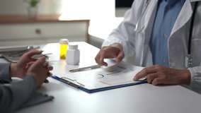 A doctor is talking to a patient about a medical condition. The patient is holding a bottle of pills - Powered by Shutterstock - Get 15% off with code: PIKWIZARD15