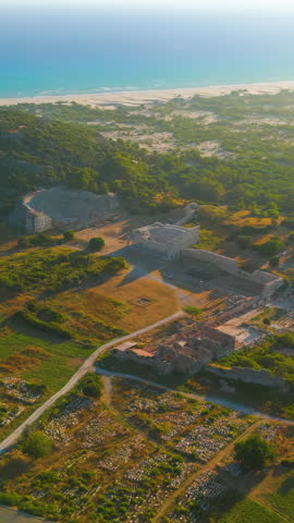 Vertical video. Gelemis, Turkey. Aerial view of Patara Beach with sand dunes and ancient theatre at sunset, Mediterranean Sea coast, summer vacation. Aerial View. Rich colors