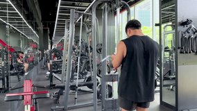 Athletic man wipes down cable machine in bright, spacious gym with natural daylight and mirrors - Powered by Shutterstock - Get 15% off with code: PIKWIZARD15