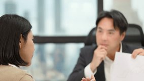 Two professionals review printed charts in bright office, engaging in animated discussion with hand gestures - Powered by Shutterstock - Get 15% off with code: PIKWIZARD15