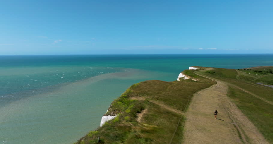 Coastal Walk On Seven Sisters Cliffs Overlooking The Beachy Head Lighthouse And English Channel In Sussex, England, UK. - aerial shot