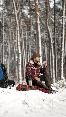 Enjoy serene moments as a traveler relaxes in a winter forest Snow blankets the ground