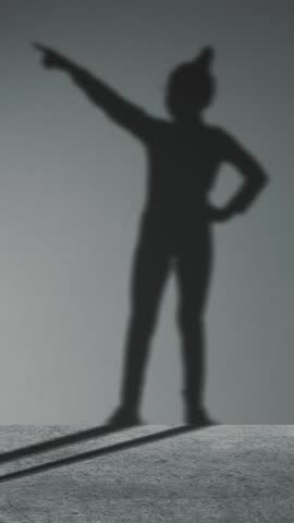 Smart Teenager girl pretends to be businessman, super hero with successful ideas. Imagination and motivation , start up, business idea concept. dancing shadow on wall.