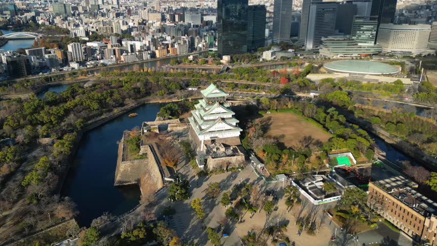Hyperlapse drone shot circling the Osaka castle, sunny, autumn day in Japan