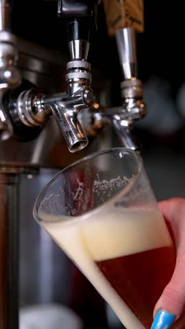 Pouring beer from tap into a glass, close-up, refreshing drink concept