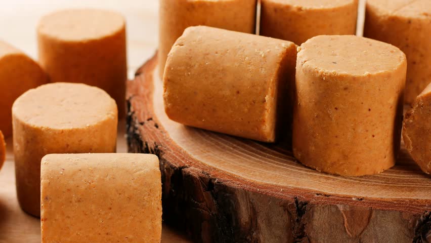Brazilian peanut candy, traditionally known as pacoca or pacoquinha, on a wooden table. Selective Focus