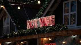 Neon HOT WINE sign on a wooden Christmas market stall decorated with garlands and festive lights. - Powered by Shutterstock - Get 15% off with code: PIKWIZARD15