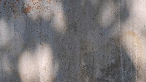 A textured, weathered concrete wall with patches of rust-colored stains and dappled shadows from overhead foliage. The surface has a rough, granular appearance - Powered by Shutterstock - Get 15% off with code: PIKWIZARD15
