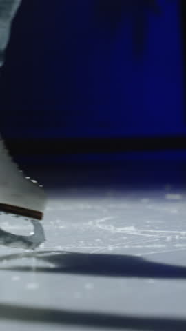 A vertical close-up of ice skating on the rink. woman legs