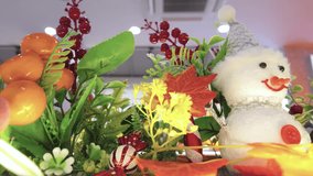 A cheerful indoor holiday scene with a plush snowman ornament nestled among lush plants, berries, and autumn leaves, creating a warm, festive atmosphere ideal for Christmas decor and home celebrations - Powered by Shutterstock - Get 15% off with code: PIKWIZARD15