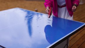 Ping-pong game, group of friends playing ping pong in a park,  play table tennis, family game in the backyard, colleagues teammates during competition at work, racket and ball on a blue tennis table - Powered by Shutterstock - Get 15% off with code: PIKWIZARD15