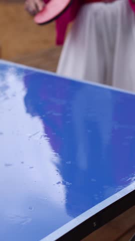 Ping-pong game, group of friends playing ping pong in a park,  play table tennis, family game in the backyard, colleagues teammates during competition at work, racket and ball on a blue tennis table