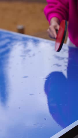 Ping-pong game, group of friends playing ping pong in a park, play table tennis, family game in the backyard, colleagues teammates during competition at work, racket and ball on a blue tennis table