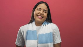 Young woman blowing kisses while smiling against a vibrant red backdrop, conveying warmth and joy. - Powered by Shutterstock - Get 15% off with code: PIKWIZARD15