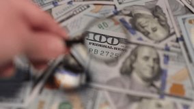 Close examination of multiple dollar bills using a magnifying glass highlights security features and details during the process. - Powered by Shutterstock - Get 15% off with code: PIKWIZARD15
