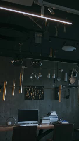 Modern chandeliers in store. Many different types and shapes of lamps, chandeliers are turning on in store showroom. assortment of illuminators for interior design.