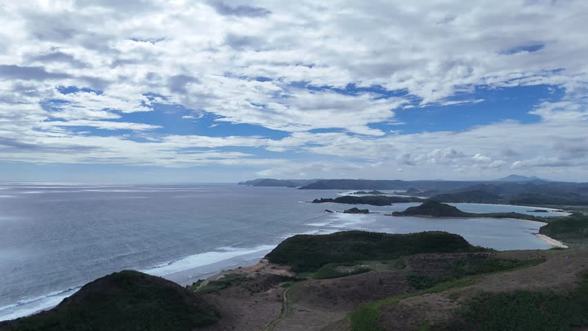 Breathtaking Coastal Panorama with Rugged Green Hills, Azure Ocean, and Serene Bays under a Dynamic Cloudy Sky