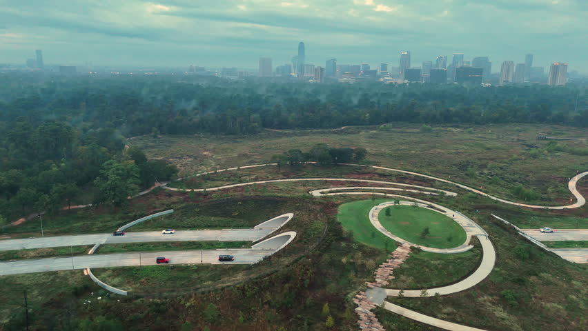 Aerial footage of the Kinder Land Bridge in Memorial Park in Houston Texas. The video shows the twin tunnels, winding paths, and restored green space with the city skyline in the distance.