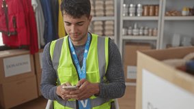 Man holds smartphone texting at center with hispanic volunteer smiling in neon vest by donation box using mobile device. - Powered by Shutterstock - Get 15% off with code: PIKWIZARD15