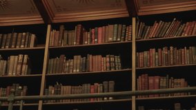 Close-up of classic wooden bookshelves filled with aged, colorful leather-bound books under warm light, capturing the timeless charm of a historic library interior. - Powered by Shutterstock - Get 15% off with code: PIKWIZARD15