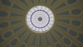Tilt shot of a grand circular library interior with high arched windows, domed ceiling, and towering wooden bookshelves filled with books, illuminated by soft natural light and classic reading lamps. - Powered by Shutterstock - Get 15% off with code: PIKWIZARD15