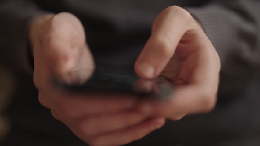 Female hands holding modern smartphone, with fingers scrolling through screen, representing digital communication, internet connectivity, and mobile device usage in daily life, close-up, slow motion.